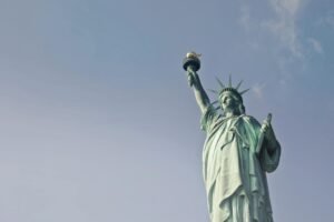 Low angle view of the Statue of Liberty against a clear blue sky, symbolizing freedom in New York.