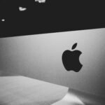 Close-up of a black and white Apple logo on a desktop screen with a modern minimalist design.