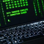 Close-up of a laptop screen displaying green code text. Perfect for cybersecurity themes.