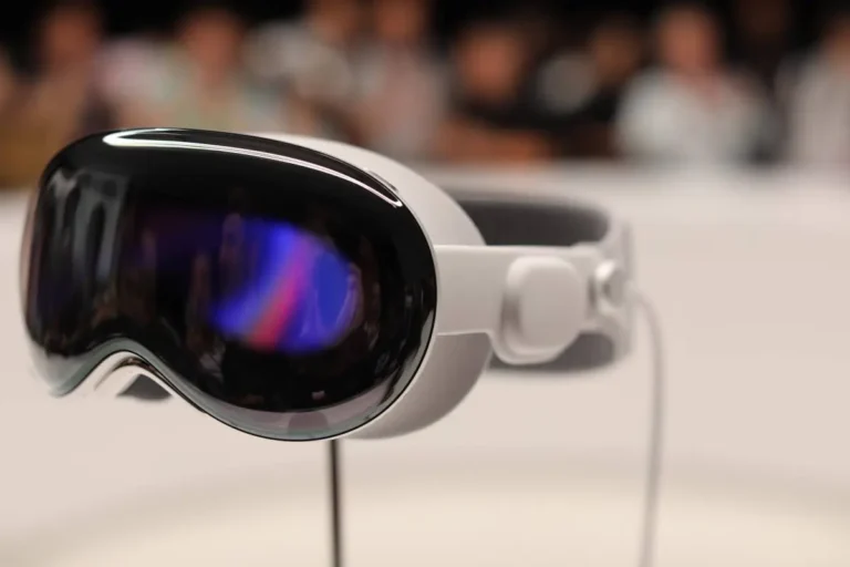 Close-up of sleek, modern VR headset with reflective black visor on a blurred background.