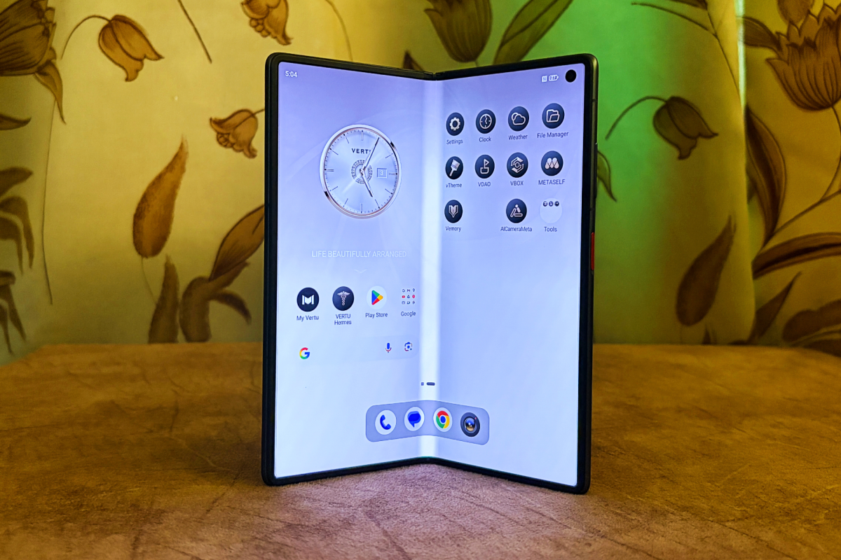 Foldable smartphone displaying apps and a clock interface, set against a floral wallpaper background.