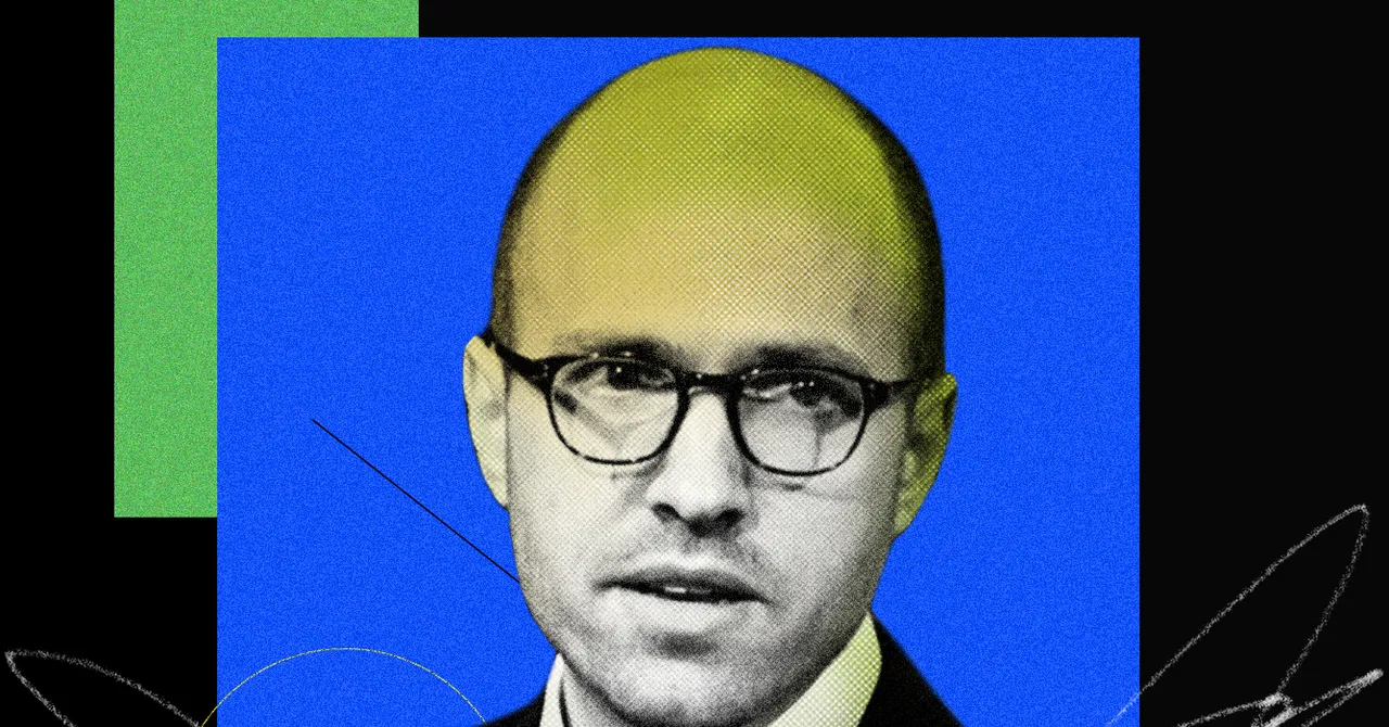 Man with glasses against a blue and green geometric background, wearing a suit and looking towards the camera.