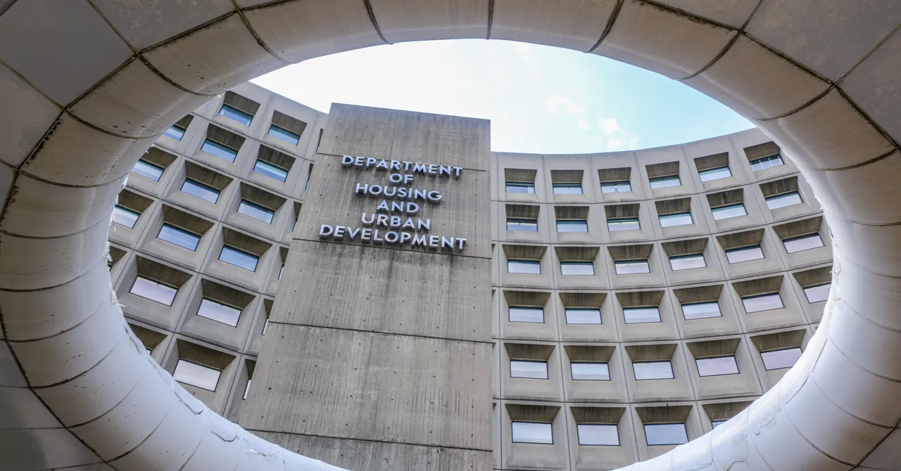 Circular view of the Department of Housing and Urban Development building facade with visible windows and sky.