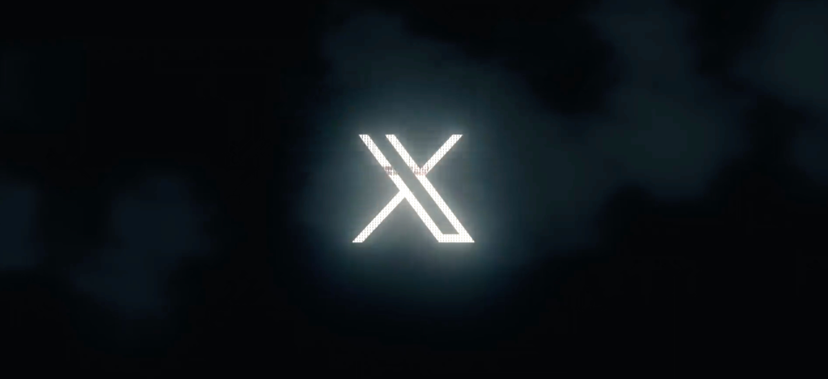 Glowing white "X" logo on a dark, smokey background.