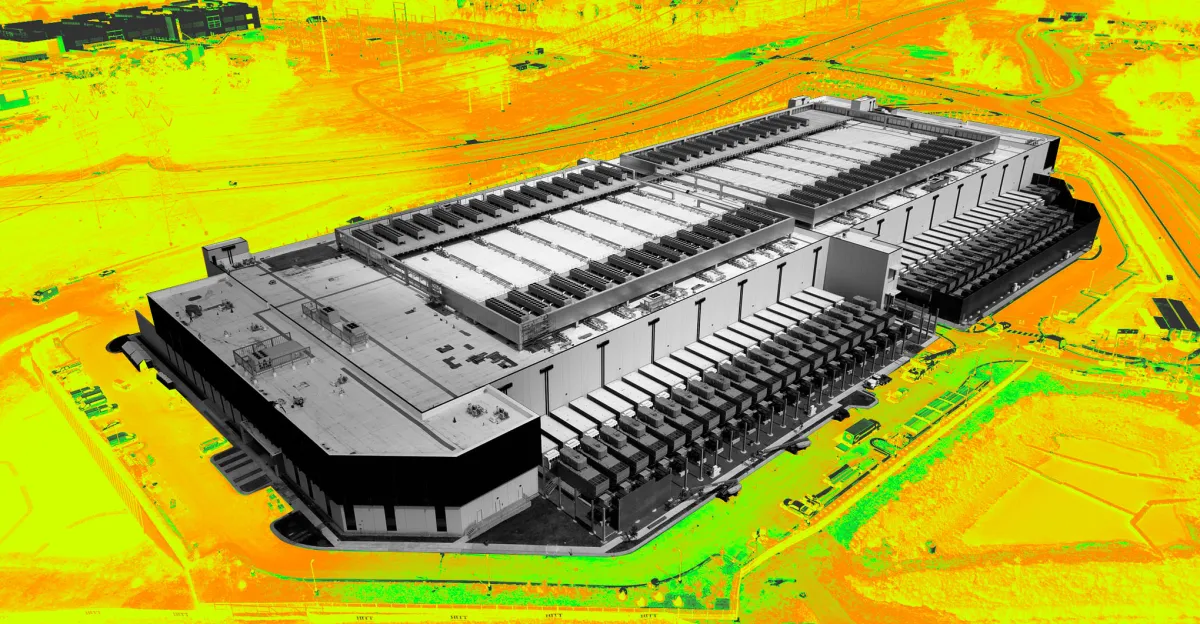 Aerial view of a large data center with a vivid, digitally altered background in yellow and green tones.