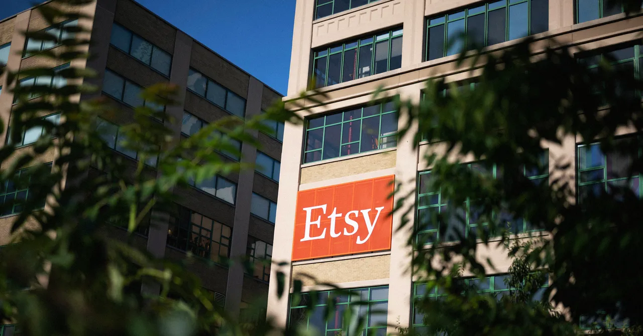 Etsy logo displayed on a large office building, partially obscured by leafy branches in the foreground.