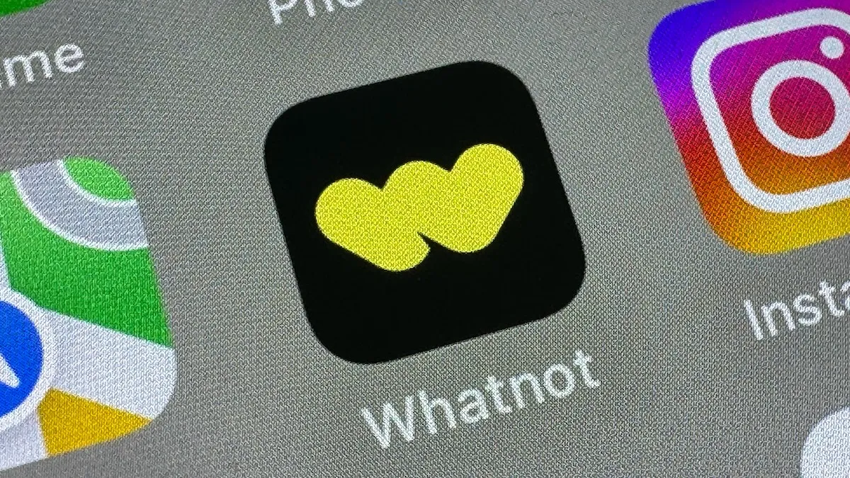 Whatnot app icon with a yellow logo on a black background, displayed on a smartphone screen alongside other app icons.