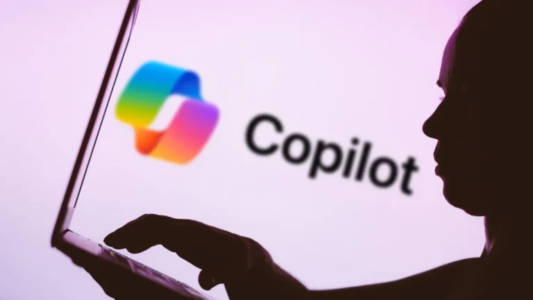 Silhouette of a person typing on a laptop with the Copilot logo and text on a pink background.