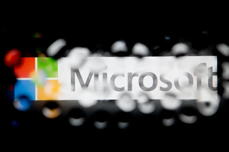 Microsoft logo with bokeh effect, blurred on black background.