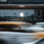 OpenAI lawsuit headline displayed beside Apple logo and laptop on desk