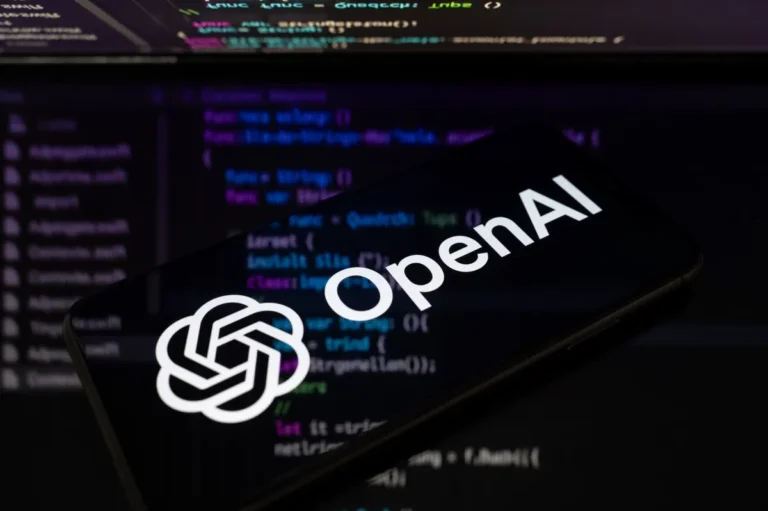 OpenAI logo on a smartphone screen with computer code in the background, symbolizing technology and programming.