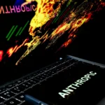Laptop keyboard with colorful digital graphics on screen, the word "Anthropic" displayed prominently.