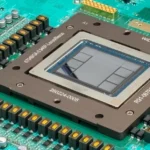 Close-up of a microchip on a green circuit board with various electronic components and visible alphanumeric markings.