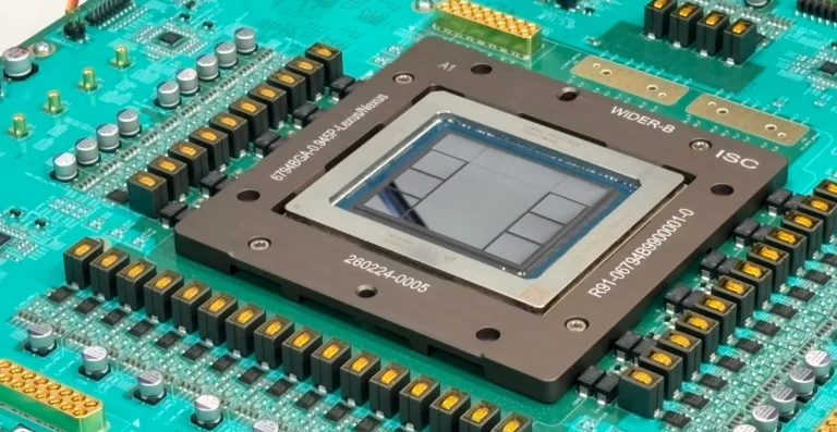 Close-up of a microchip on a green circuit board with various electronic components and visible alphanumeric markings.
