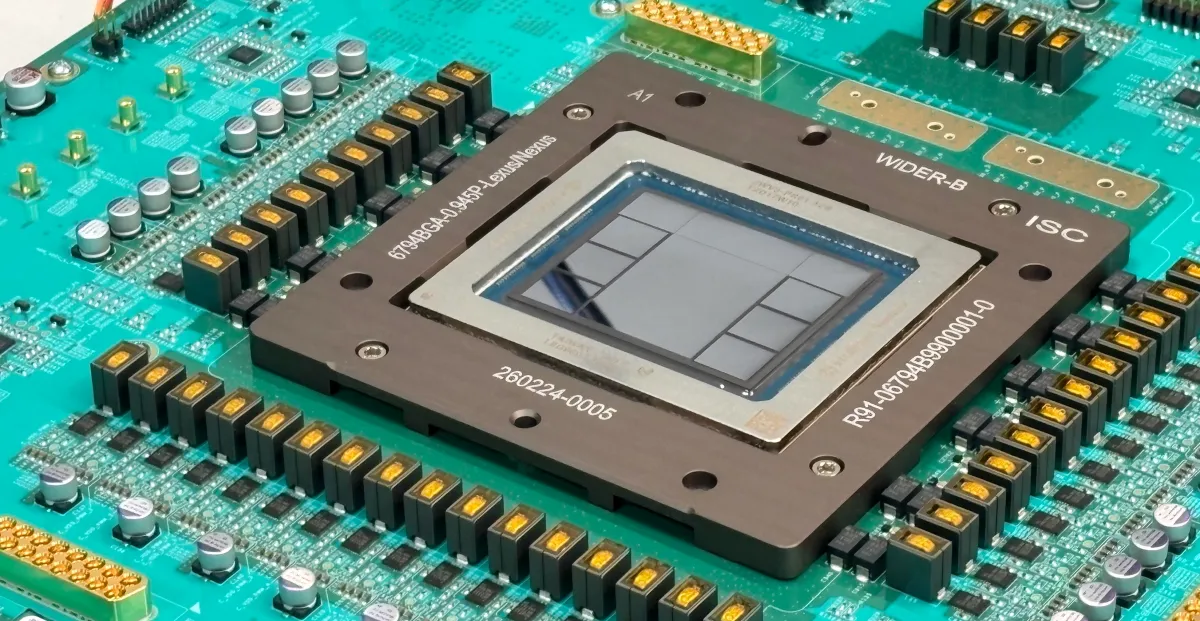 Close-up of a microchip on a green circuit board with various electronic components and visible alphanumeric markings.