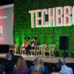 Speakers seated on stage at TechBBQ event, discussing "Sovereign AI & The Last Economy" with audience in foreground.