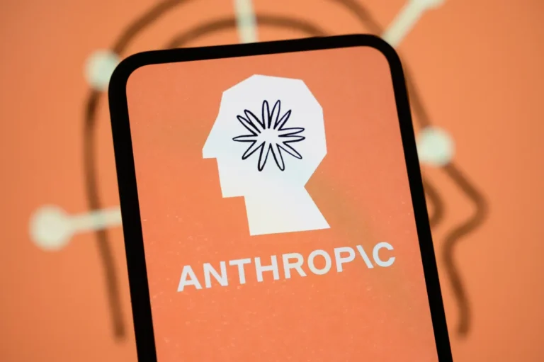 Smartphone screen displaying Anthropic logo with stylized head and starburst design on an orange background.