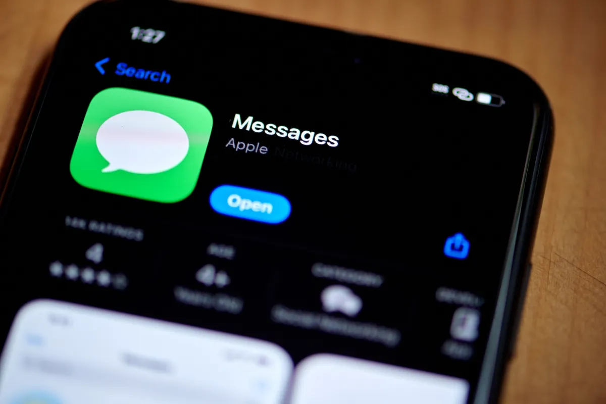 Close-up of an iPhone screen displaying the Apple Messages app in the App Store with the option to open it.