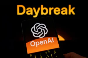 OpenAI logo on a smartphone screen with "Daybreak" text in the background, both on dark, orange-themed displays.