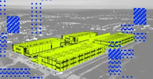 Aerial view of a large data center in yellow, surrounded by blue pixelated patterns, with residential area in the background.