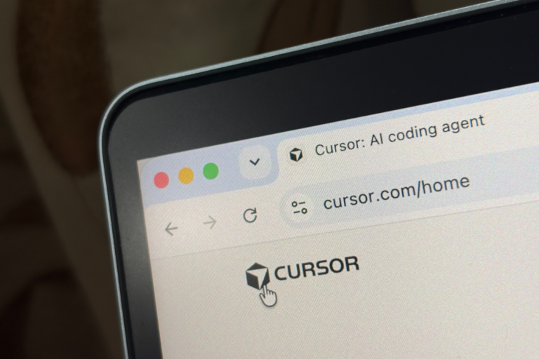 Laptop screen displaying a webpage with the URL cursor.com/home and the text "Cursor: AI coding agent" in the tab.