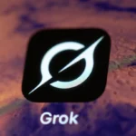 Grok app icon on a smartphone screen, featuring a stylized white symbol on a black background, with the word "Grok" below it.