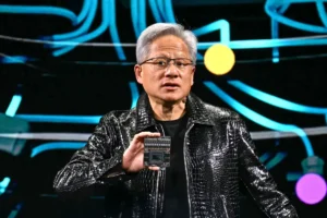 Person in a black jacket holds a computer chip, colorful abstract background with blue and yellow lines and circles.