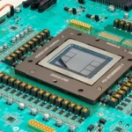 Close-up of a computer chip on a green circuit board with visible components and labeled text.