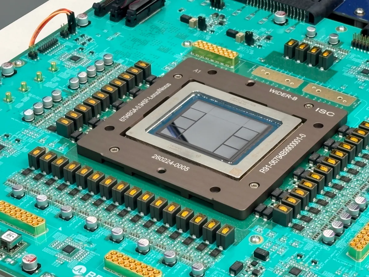 Close-up of a computer chip on a green circuit board with visible components and labeled text.