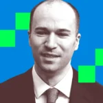 Man in a suit with a neutral expression, blue background with green squares.