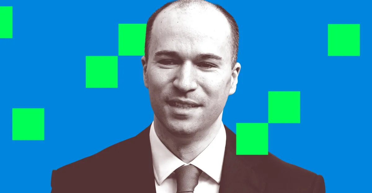Man in a suit with a neutral expression, blue background with green squares.