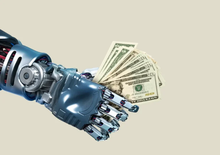 Robotic hand holding a fan of US dollar bills against a plain background.