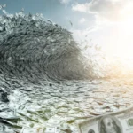 A wave of US hundred-dollar bills forming a tunnel under a partly cloudy sky.