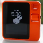 Orange electronic device with a screen displaying 91% battery, 5:30 time, and a rabbit logo on a white surface.
