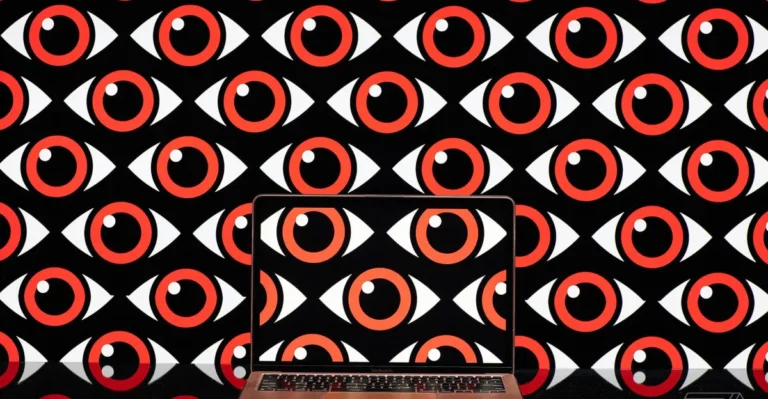 Laptop displaying red and white eye pattern, matching the background, symbolizing surveillance or scrutiny.