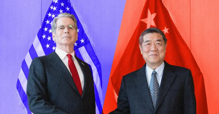 Two men in suits stand in front of U.S. and Chinese flags, posing for a photo.