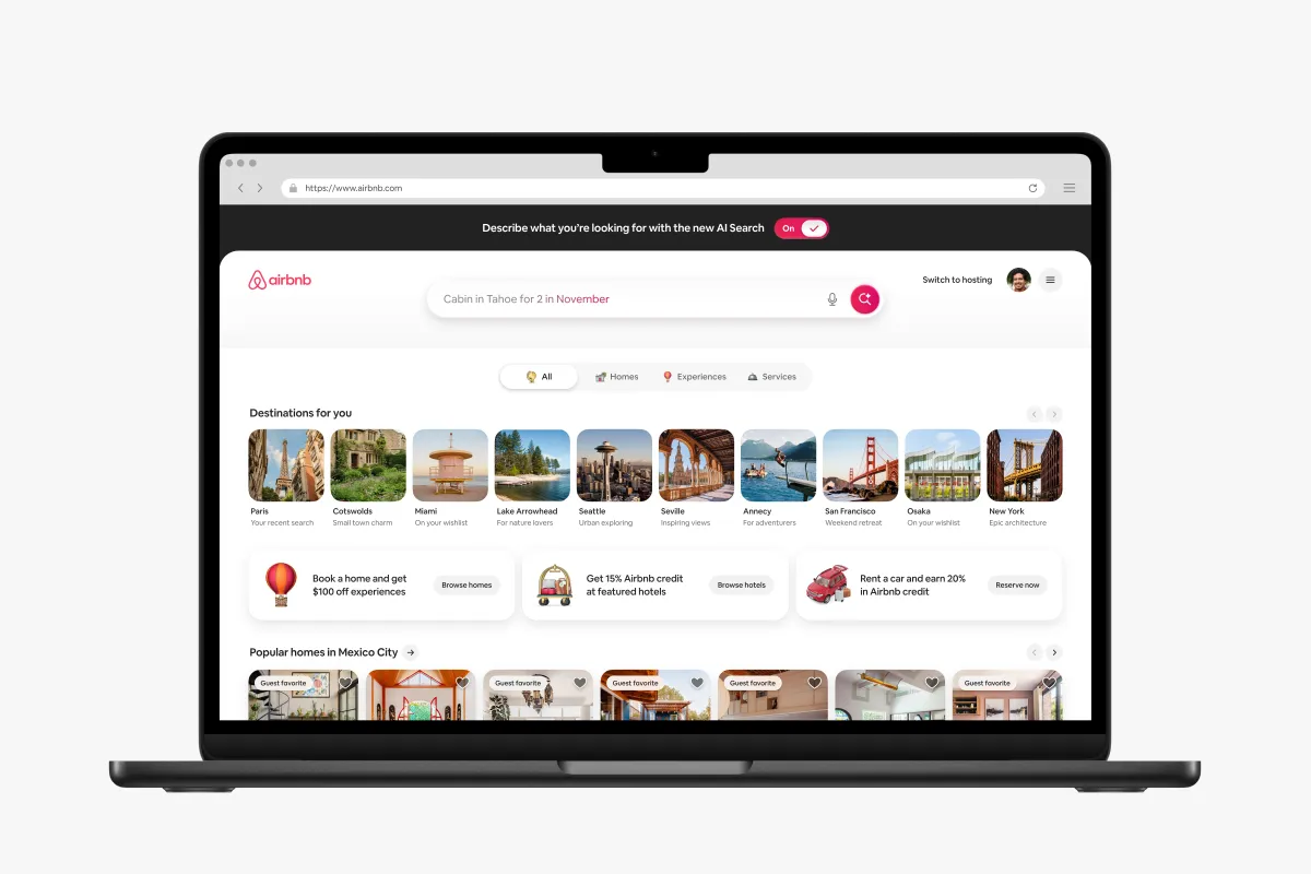 Laptop screen showing Airbnb's website with AI search bar, travel destinations, and promotional offers.
