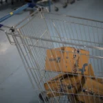 Shopping cart with Flipkart packages inside, blue floor, and more carts in the background.