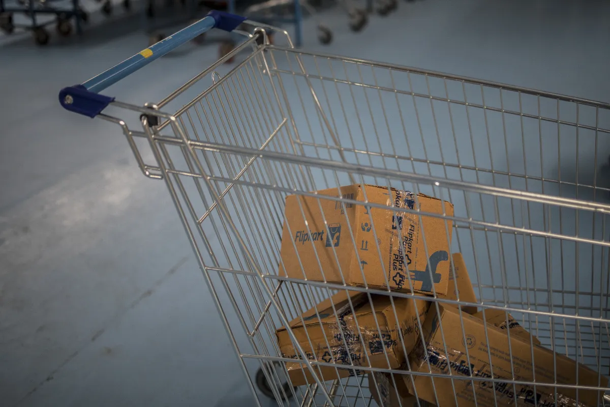 Shopping cart with Flipkart packages inside, blue floor, and more carts in the background.