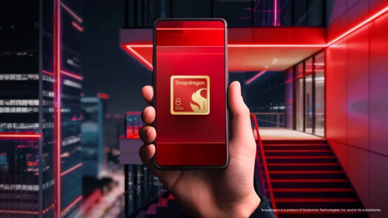 Hand holding a smartphone displaying Snapdragon 8 Elite Gen 3 logo, with a modern building and red neon lights in the back...