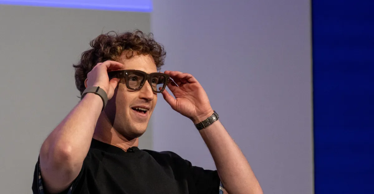 Individual wearing smart glasses and an Apple Watch, adjusting the glasses with both hands, neutral background.