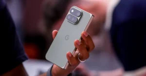 Hand holding a Google Pixel smartphone with dual rear cameras, blurred background.