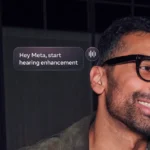 Man wearing smart glasses smiles, on-screen text reads "Hey Meta, start hearing enhancement.