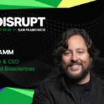 Smiling man with wavy hair, text: "Disrupt, Oct 13-15, San Francisco, Ben Lamm, Founder & CEO, Colossal Biosciences" on a...