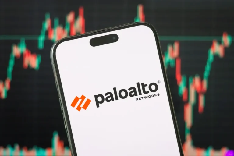 Smartphone displaying Palo Alto Networks logo, set against a blurred background of colorful stock market graphs.