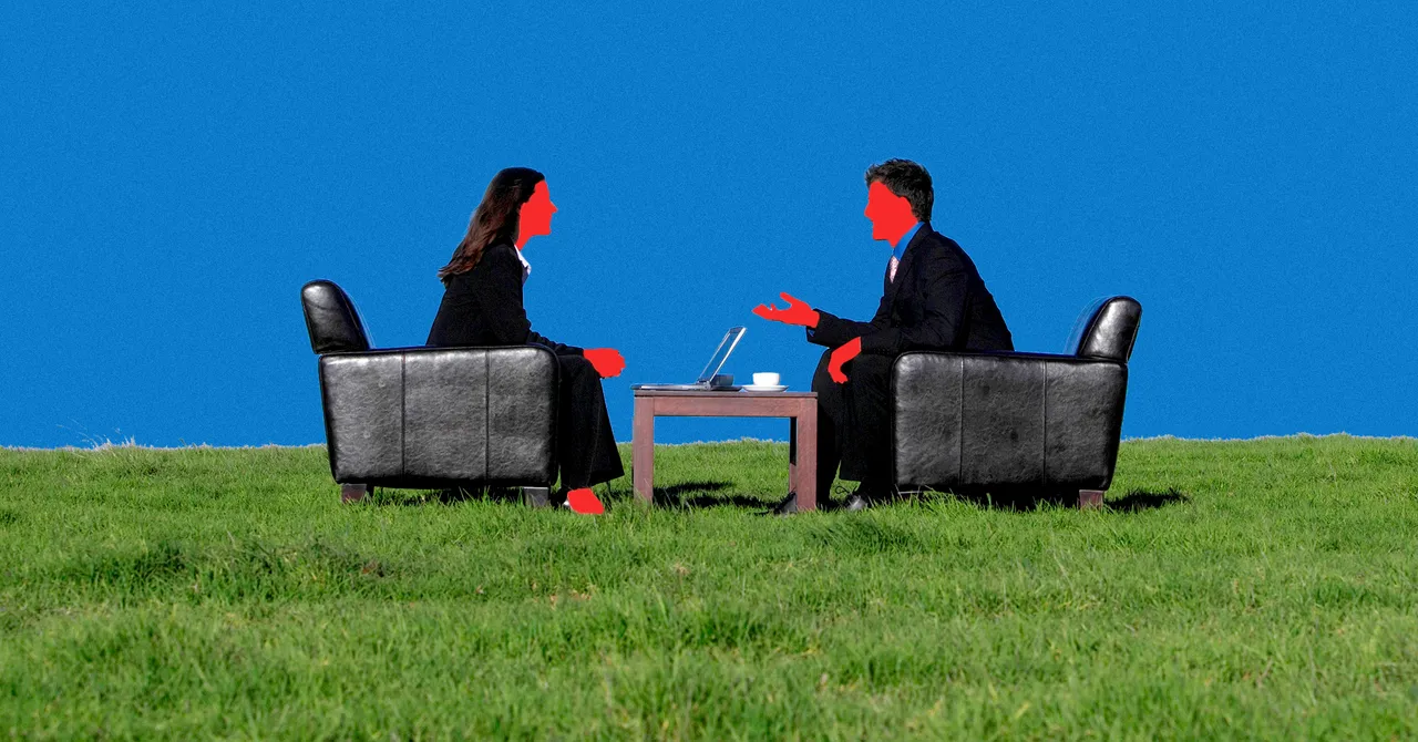 Two people in suits converse over a laptop on chairs in a grassy field, against a vivid blue background.