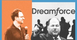 Two men speaking at Dreamforce event, one holding a microphone, with silhouettes and Dreamforce logo in the background.