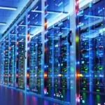 Rows of illuminated server racks in a data center with colorful LED lights reflecting on glass doors