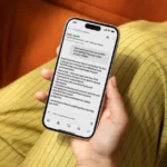 Hand holding a smartphone displaying a message from Alexa for shopping, verifying an OTP text from Amazon.