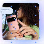 Person holding a pink smartphone with a "G" logo, text overlay reads "Motion assist On". Blue dots scattered on image.